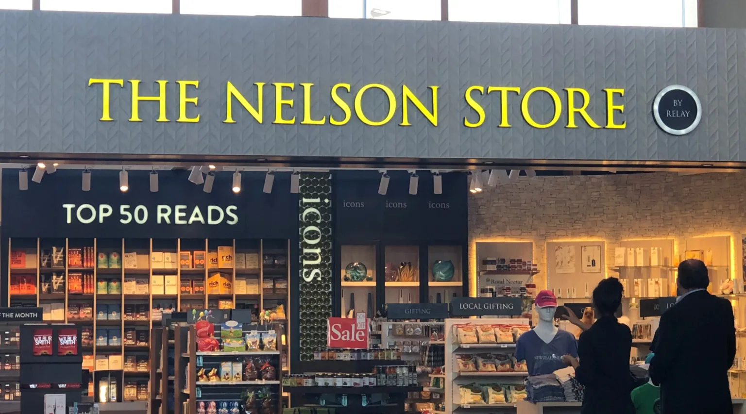Internally illuminated fabricated letters with yelow acrylic face reading "The Nelson Store" on a grey internal fascia over a retail store