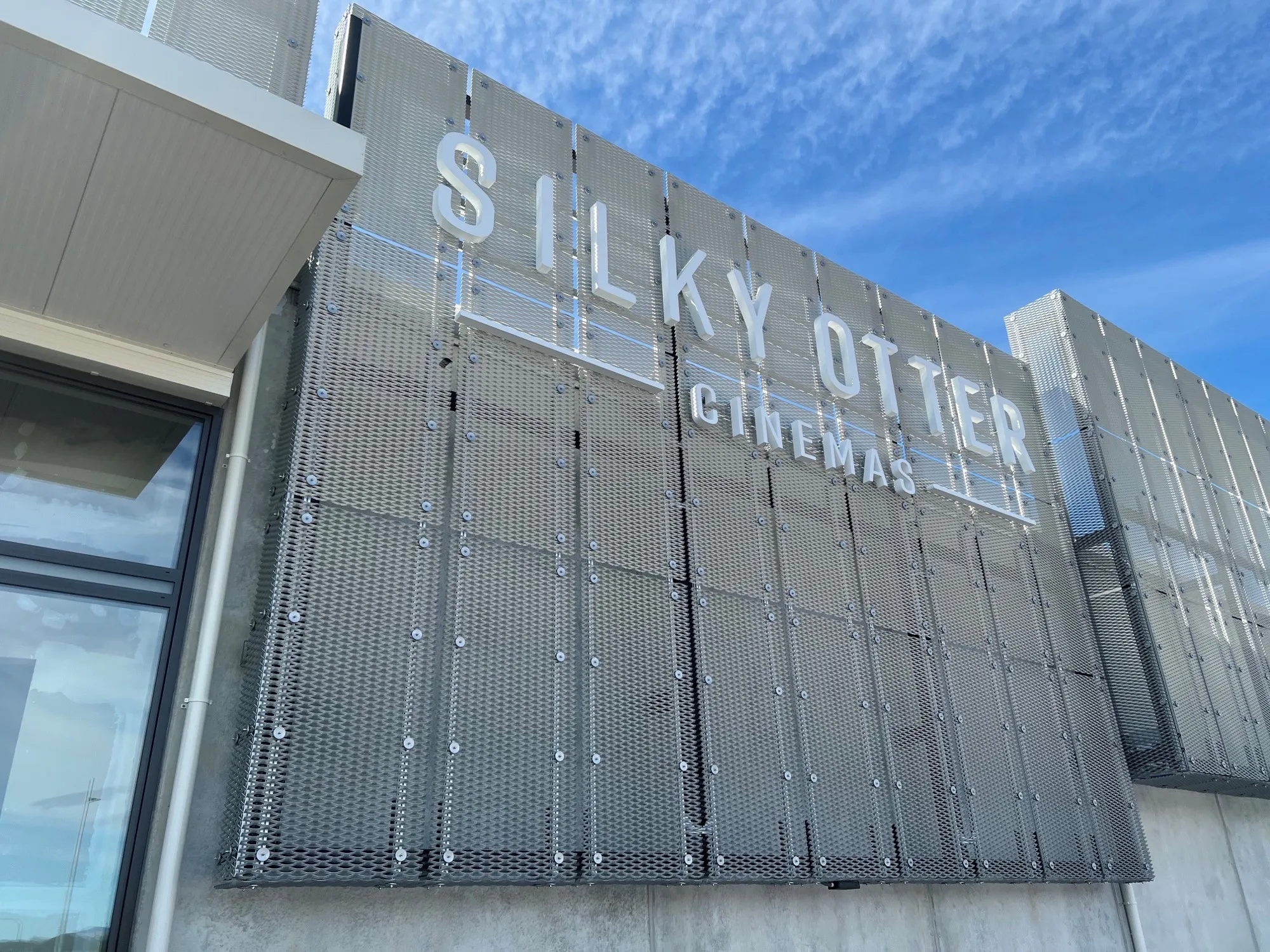 Fabricated 3D lettering reading Silky Otter Cinemas mounted onto a woven mesh fascia